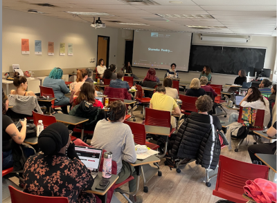 graduate students and faculty sitting at desks in a classroom